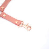 Pink leather bondage hogtie strap with rose gold quick-release clip and rivets from the Pink Dream collection