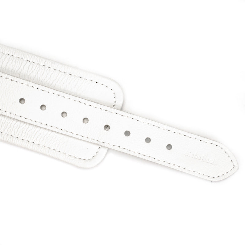 Close-up of white leather ankle cuff strap with silver metal buckle holes and detailed stitching, part of the Fuji White BDSM collection