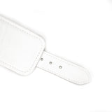 Close-up of Fuji White leather handcuff strap with adjustable silver buckle holes for BDSM wrist restraints