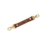 Equestrian leather bondage strap with vintage gold hardware and adjustable holes, ideal for enhancing BDSM ankle restraints