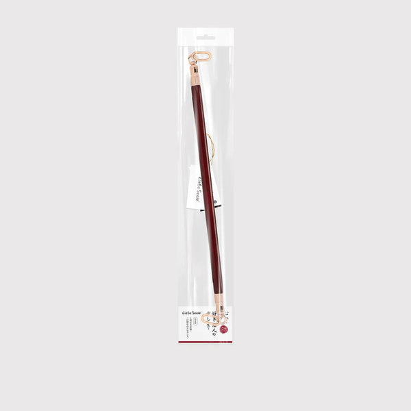 Wine red leather-coated spreader bar with rose gold accents, displayed in clear packaging, part of LIEBE SEELE's BDSM spreader bar collection