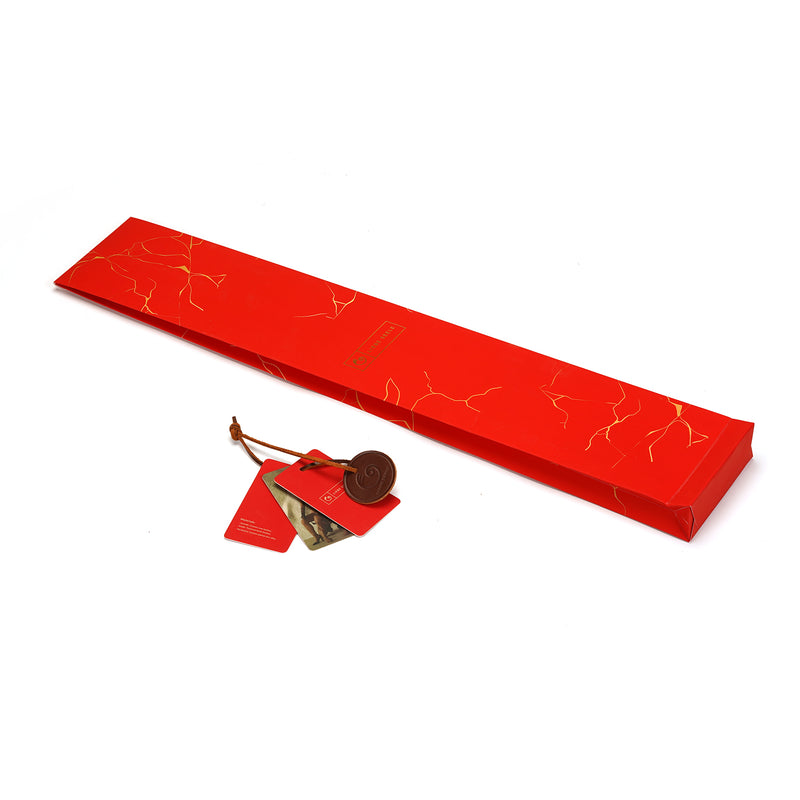 Elegant red gift box for Ratten Cane from The Equestrian collection, featuring a patterned surface and branding tag