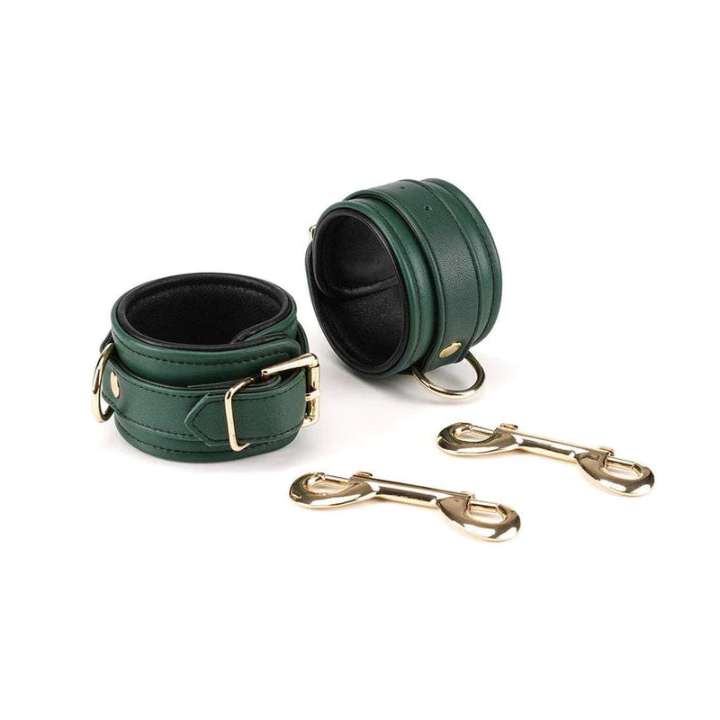 Mossy chic leather wrist cuffs set in blackish-green with gold hardware, showing soft sheepskin lining and included metal clips for bondage play
