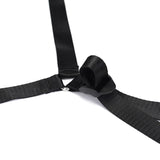 Close-up of black adjustable webbing belts with metal clip for under mattress restraint system, suitable for bondage play