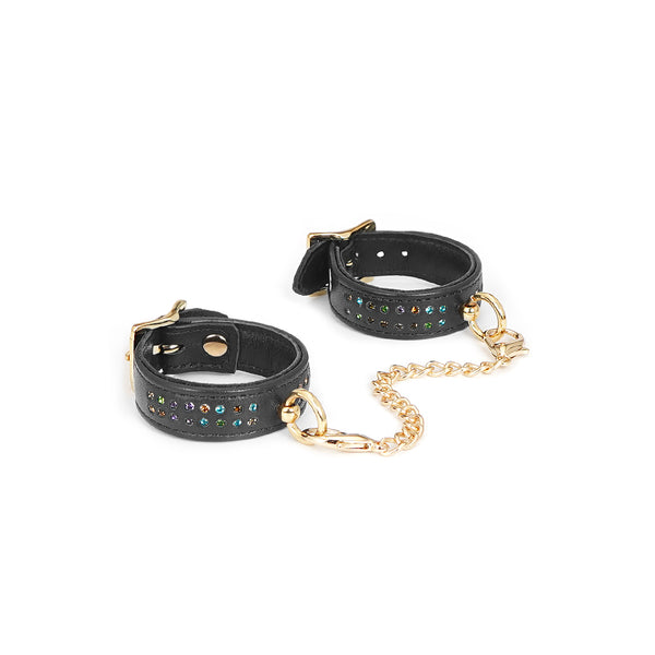 Shining Girl black leather wrist cuffs with embedded gems and gold connecting chain, suitable for bondage play