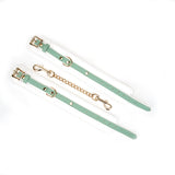 White and green leather ankle cuffs with gold hardware from Fairy bondage accessories collection