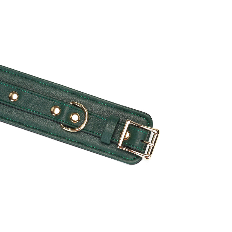Close-up of Mossy Chic green leather wrist cuff with gold buckle and rivets, adjustable bondage wrist restraints