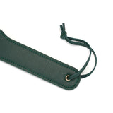 Mossy Chic Dual Sensation Leather Spanking Paddle featuring a green leather surface with detailed stitching and a leather wrist strap, part of LIEBE SEELE's bondage gear collection