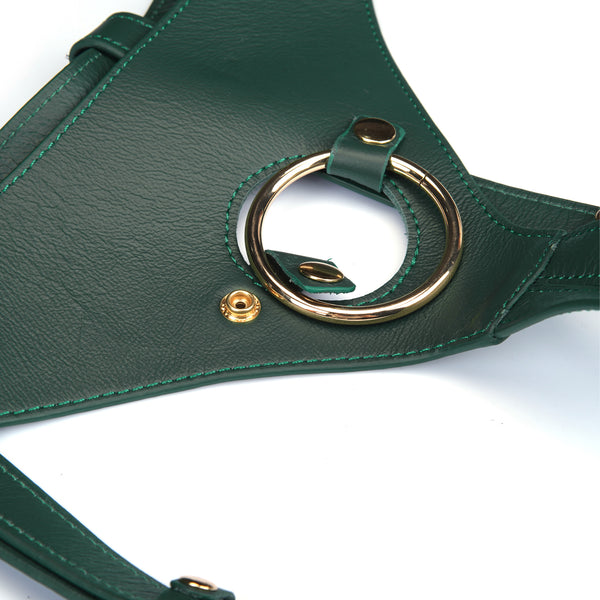 Close-up of mossy chic leather strap-on harness with gold O-ring and adjustable buckles for bondage play