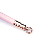 Close-up view of Fairy Pink Leather-Coated Spreader Bar with rose gold metallic clasp and O-ring for BDSM restraint play