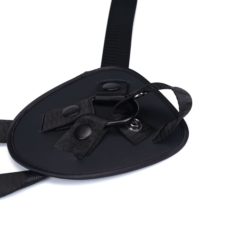 Black vegan leather strap-on harness with adjustable straps and metal enhancer ring, part of the Vegan Fetish collection