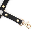 Close-up of black leather hogtie with golden clip and rivets from the Dark Secret collection for BDSM play
