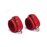 Red faux leather wrist cuffs with adjustable straps and metal buckles for bondage play