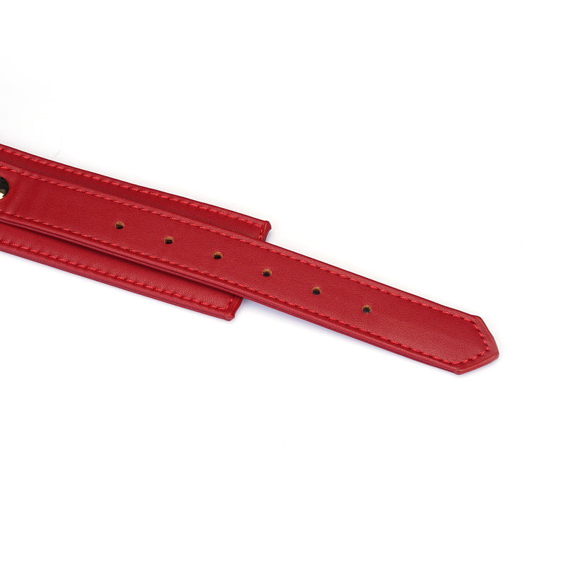 Close-up view of adjustable red faux leather collar with precision stitching and multiple holes for custom fitting