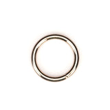 Golden metallic ring used for bondage gear on a white background, highlighting simple design and polished finish