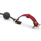 Kinbaku Ukiyoe Ball Gag with adjustable red rosy lamb suede leather strap and black silicone ball, showcasing intricate copper-plated hardware