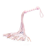 White and pink leather flogger whip from the Fairy Leather collection, featuring a braided handle for enhanced grip during impact play