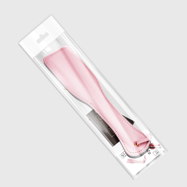 Pink leather spanking paddle from LIEBE SEELE's Fairy collection, featuring quality stitching and a leather wrist strap, presented in a clear display box