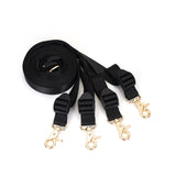 Under mattress restraint system with adjustable black webbing belts and gold-tone clips for bondage play