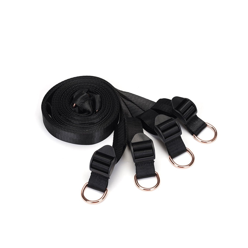 Under Mattress Restraint System with adjustable black webbing belts and copper-toned D-rings for secure bondage play