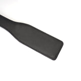 Black leather spanking paddle from Demon's Kiss collection with luxuriously smooth ostrich skin pattern for BDSM play