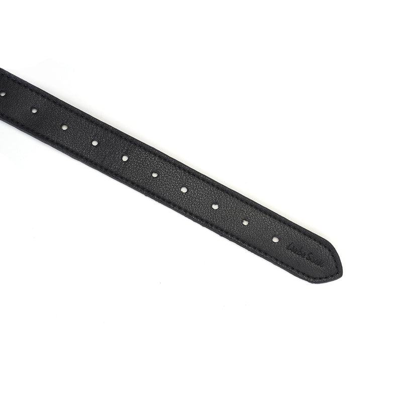 Detailed view of a finely crafted black leather strap with precision-punched adjustment holes, essential for customizing fit in BDSM gear