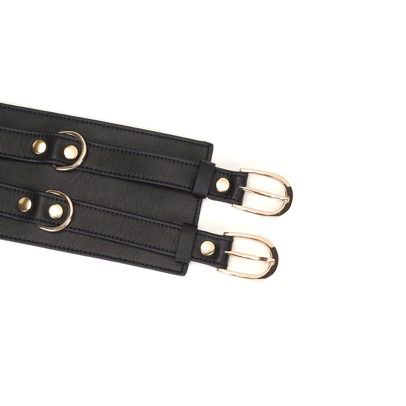 Close-up of black leather bondage belt with golden buckles, adjustable feature highlighted, part of the Dark Secret collection