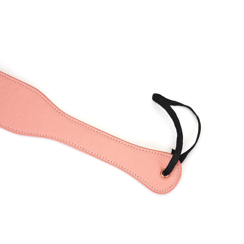 Baby pink leather spanking paddle from Pink Dream collection, featuring a black loop handle and neat stitching for durability